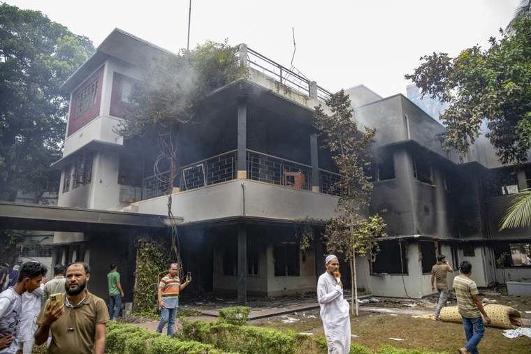 La gente se reúne en el Museo Memorial Bangabandhu después de que fuera incendiado por manifestantes antigubernamentales 