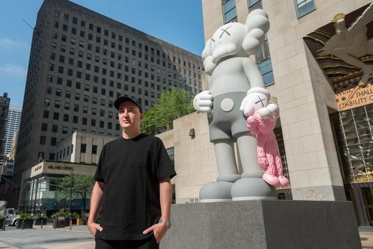 Brian Donnelly (KAWS) y su escultura SHARE en el Rockefeller Center de Nueva York y que representa dos de los icónos del artista, 'COMPANION' y 'BFF'