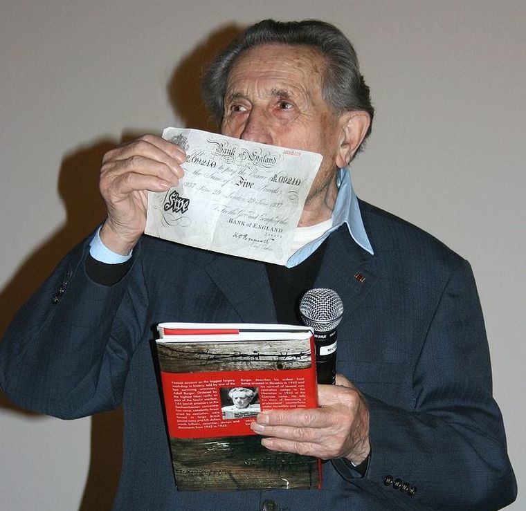 Adolf Burger, tipógrafo judío forzado a trabajar en la Operación Bernhard, mostrando uno de los billetes falsos. 