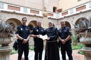Miembro del Grupo de Patrimonio Histórico de la Policía de la Generalitat hacen entrega del libro recuperado.